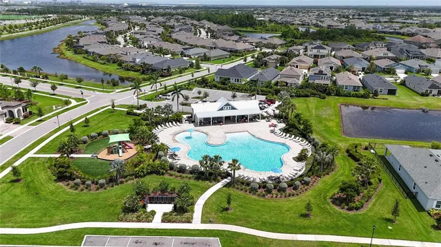 an aerial view of residential houses with outdoor space and trees