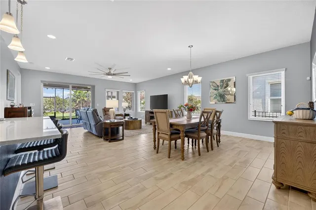 a living room with furniture a dining table a lamp and a window