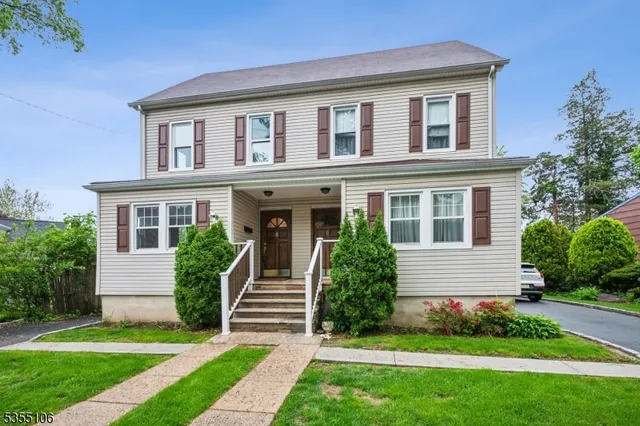 a front view of a house with a yard and green space