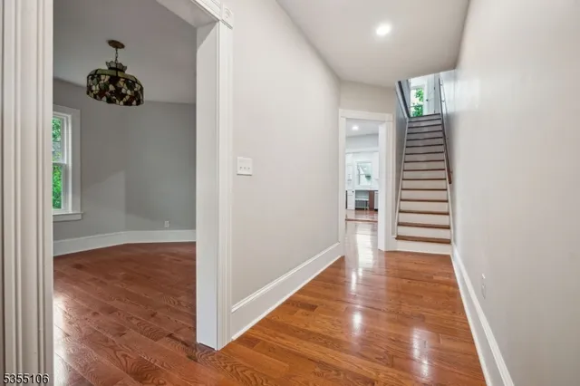 a view of a hallway with wooden floor and a living room