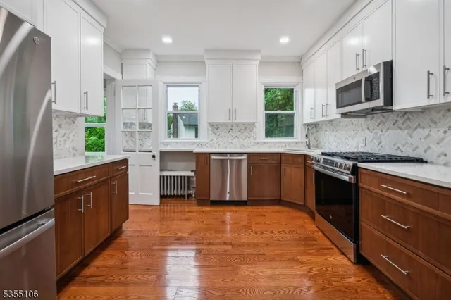 a kitchen with stainless steel appliances granite countertop a sink counter space cabinets and a large window
