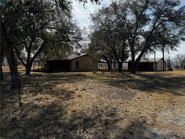 a view of a backyard with large trees