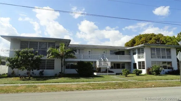 a front view of a house with a garden and plants