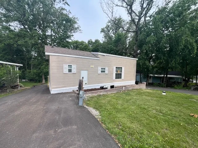 a view of a house with backyard and tree