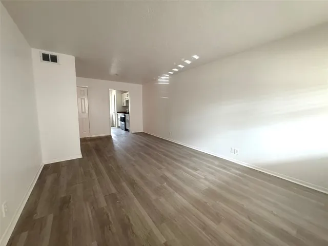 a view of an empty room with wooden floor