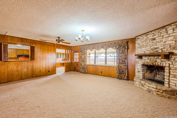 a view of an empty room with a fireplace and a window