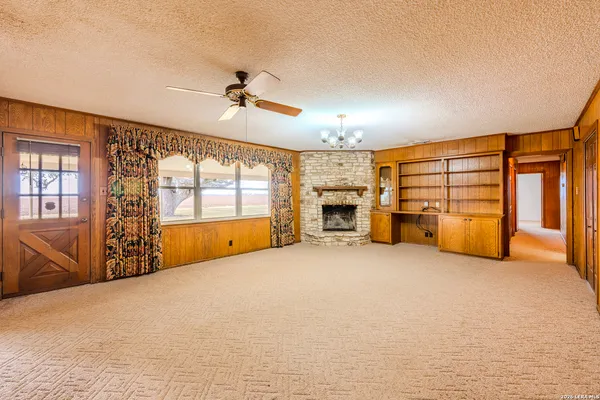 an empty room with furniture staircase and windows