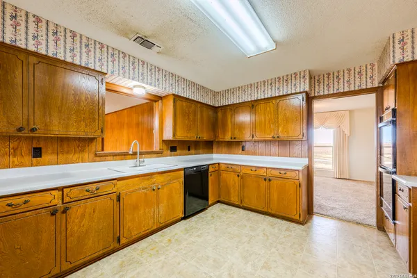 a large kitchen with stainless steel appliances granite countertop a sink and cabinets