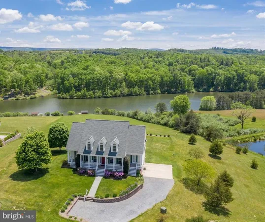 an aerial view of a house with a garden and lake view