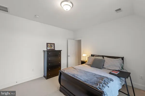 a spacious bathroom with a granite countertop sink a toilet a mirror and shower
