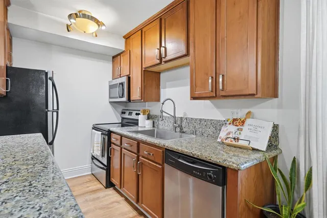 a kitchen with stainless steel appliances granite countertop a sink stove and refrigerator
