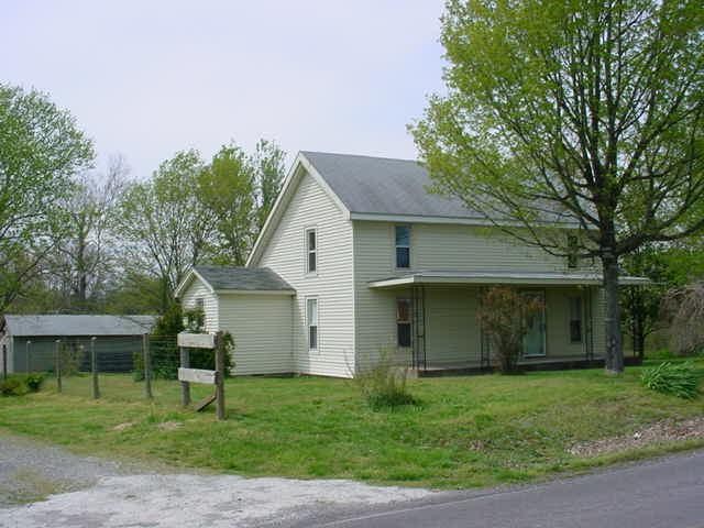 a front view of house with a garden