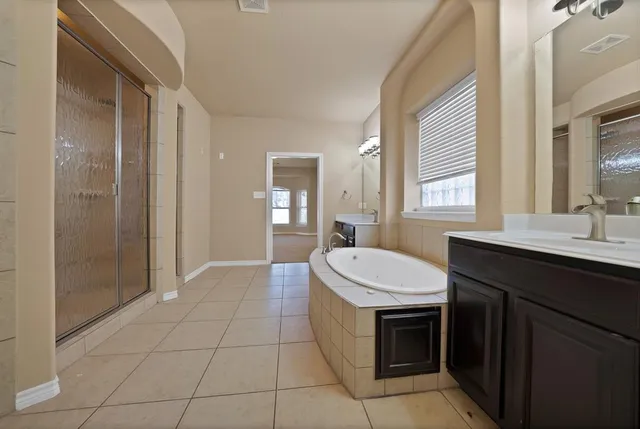a spacious bathroom with a sink a toilet and a mirror