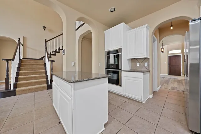 a view of kitchen with refrigerator and cabinets