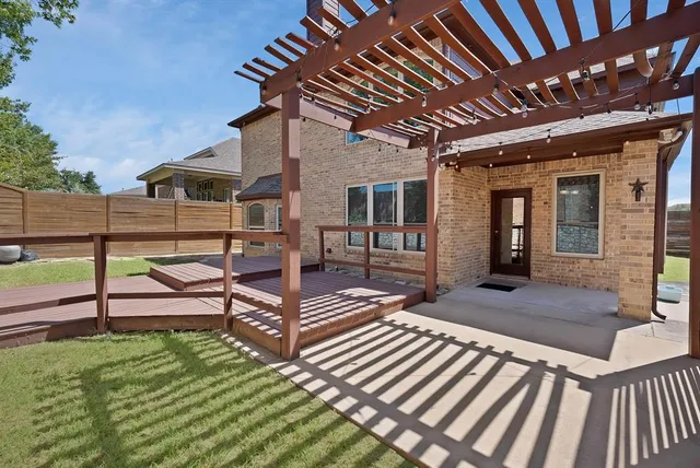 a view of a patio with table and chairs with wooden floor and fence