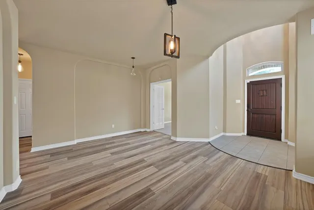 a view of an empty room with wooden floor