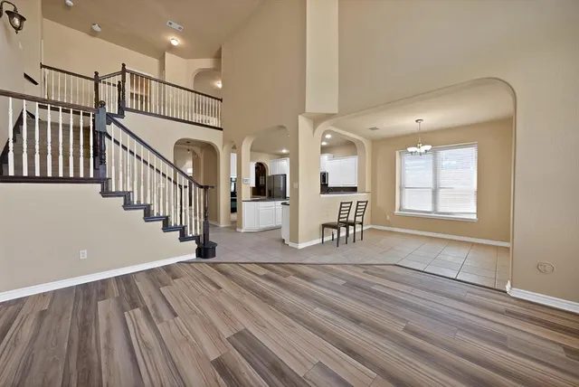 a view of a livingroom with wooden floor and stairs