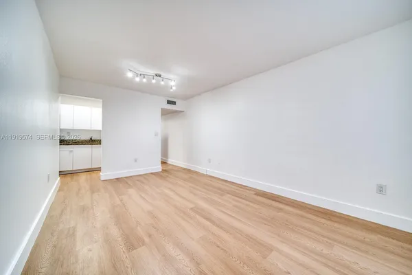 a view of a room with wooden floor and a ceiling fan