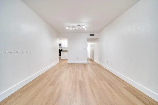 a kitchen with white cabinets and refrigerator