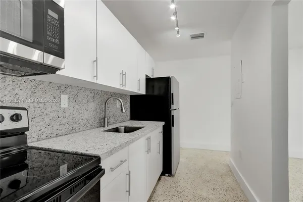 a kitchen with a sink and a stove top oven