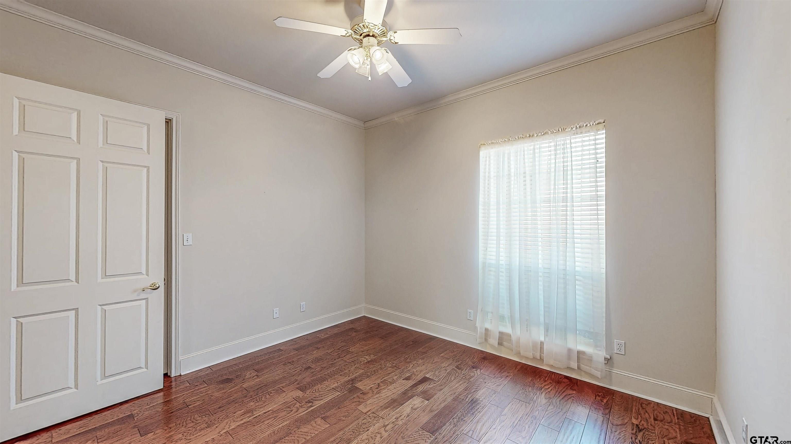 2435 Homestead Lane Tyler, TX 75701 - Photo 13 of 35 an empty room with wooden floor fan and windows