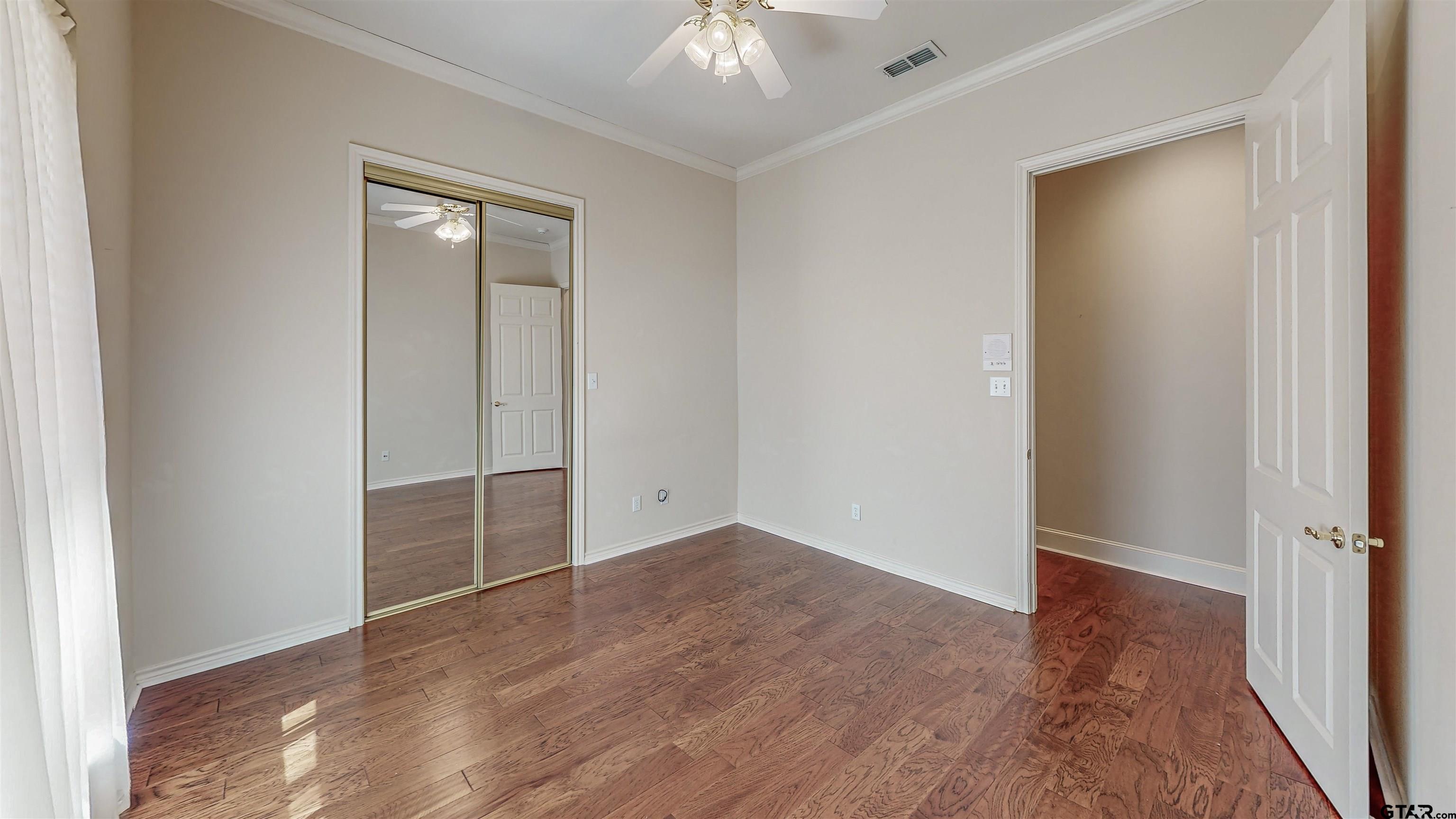 2435 Homestead Lane Tyler, TX 75701 - Photo 16 of 35 an empty room with wooden floor and a ceiling fan