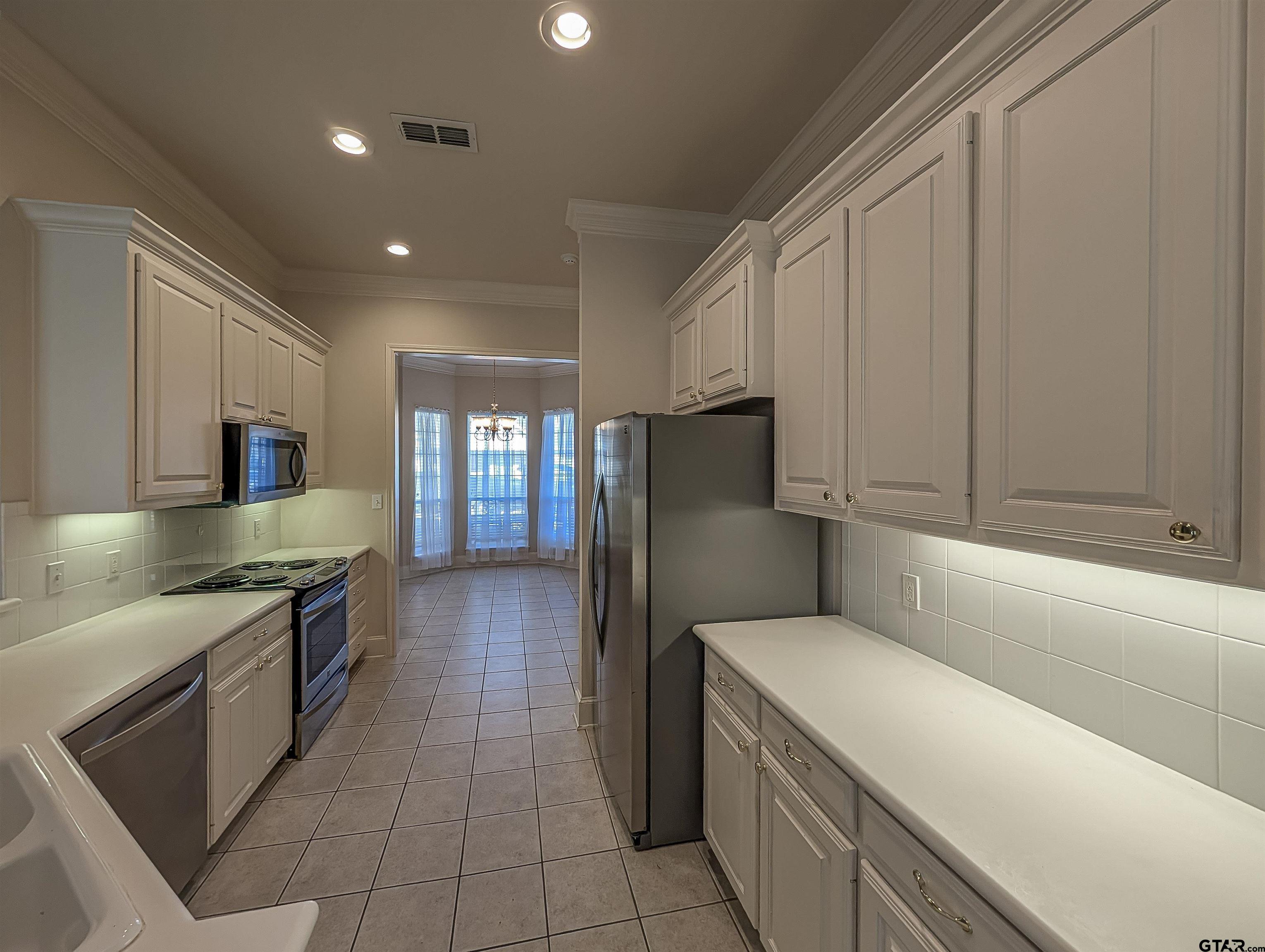 2435 Homestead Lane Tyler, TX 75701 - Photo 4 of 35 a kitchen with a refrigerator and a sink