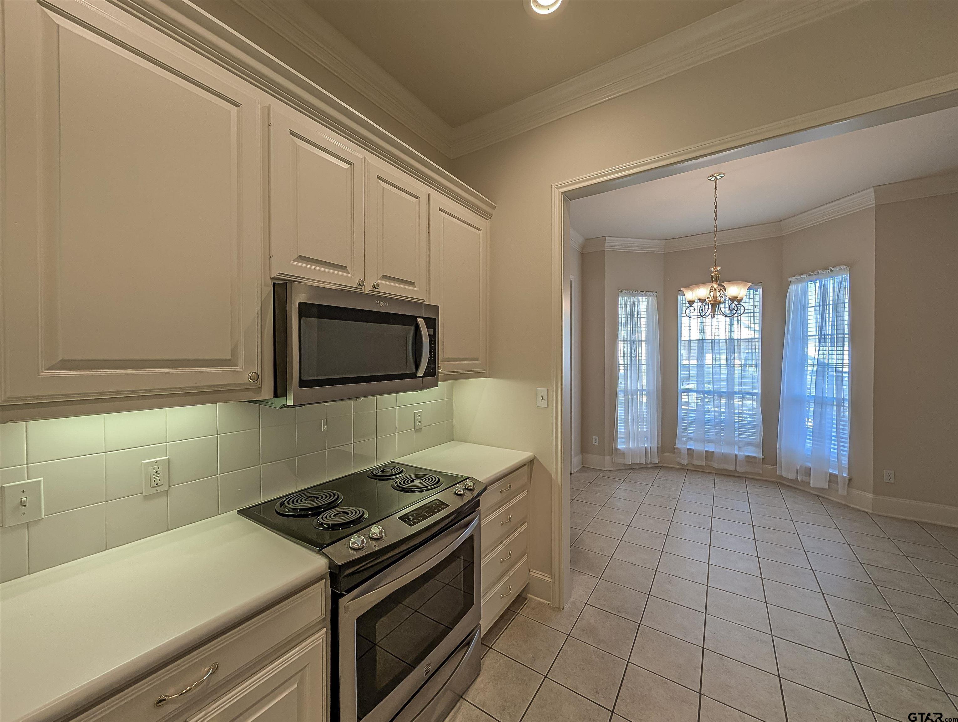 2435 Homestead Lane Tyler, TX 75701 - Photo 5 of 35 a kitchen with a stove and a microwave