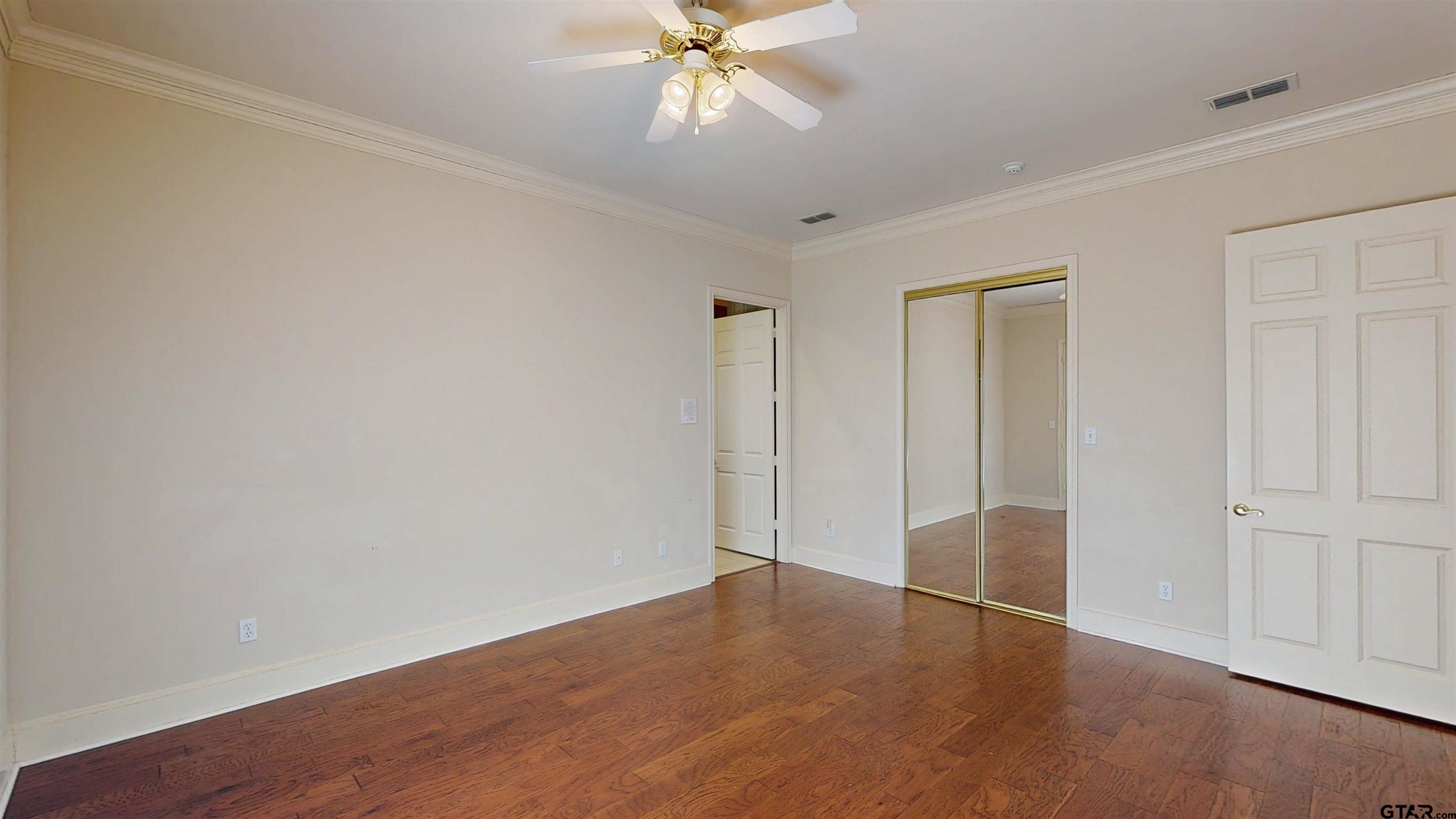 2435 Homestead Lane Tyler, TX 75701 - Photo 10 of 35 an empty room with wooden floor closet and windows