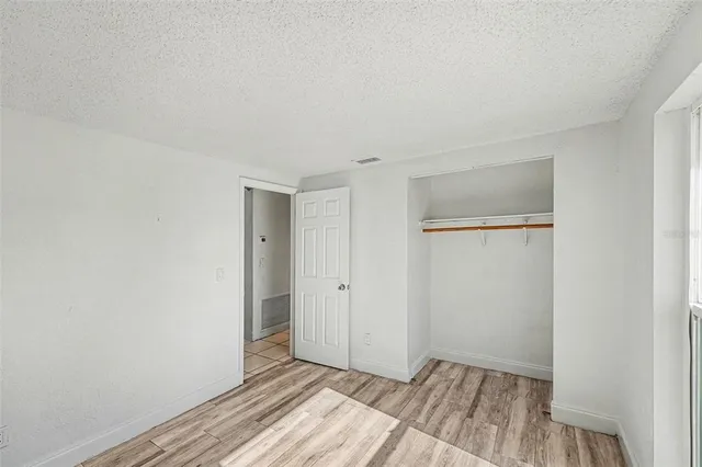 a view of a room with wooden floor and closet