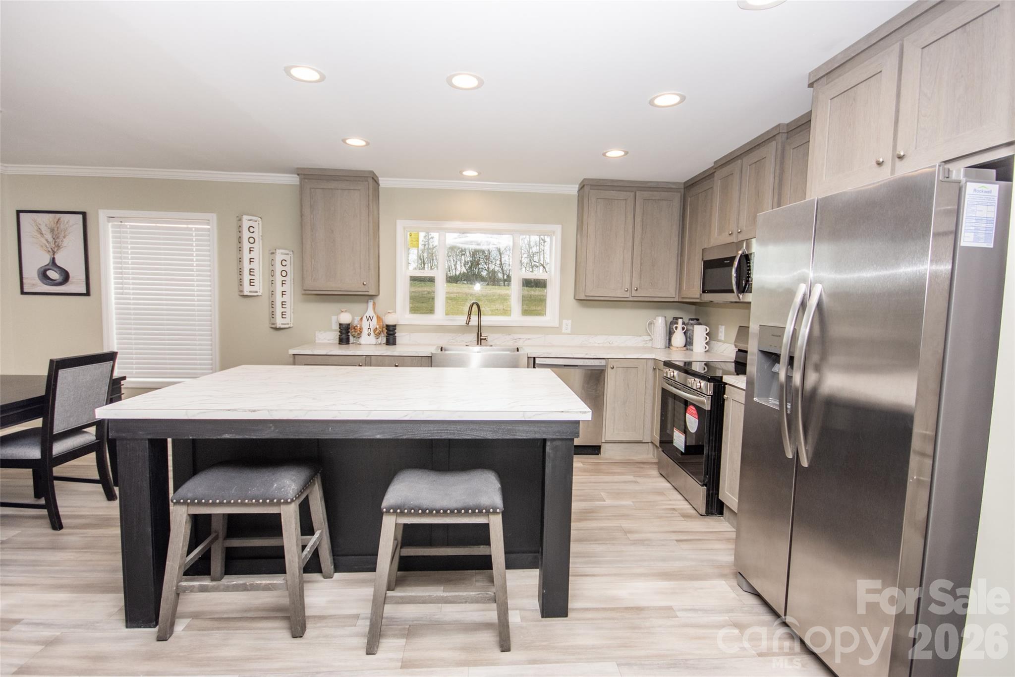 489 Eagle Mills Road Hamptonville, NC 27020 - Photo 4 of 24 a kitchen with stainless steel appliances kitchen island granite countertop a table chairs sink refrigerator and cabinets