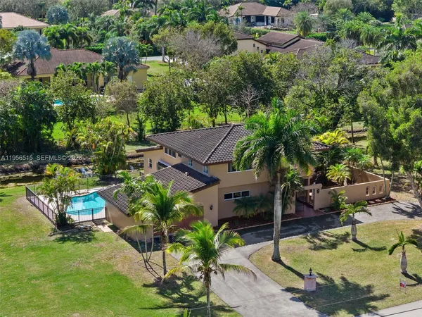 an aerial view of a house with swimming pool and lake view