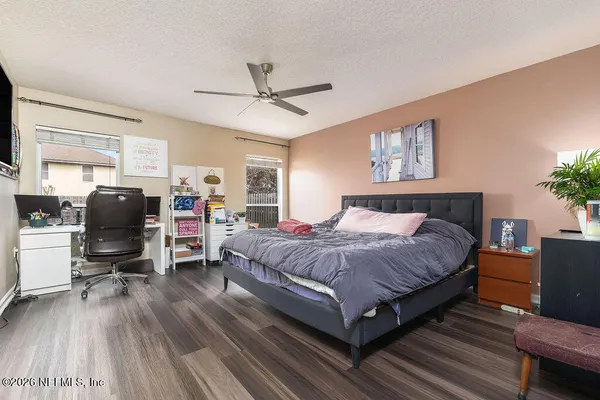 a spacious bedroom with a bed and wooden floor