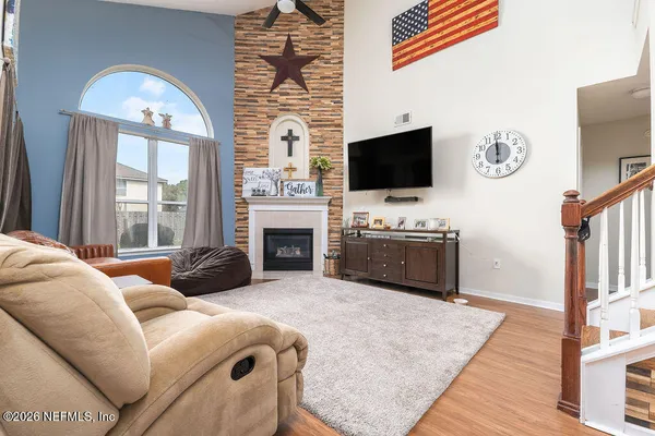 a living room with furniture a flat screen tv and a fireplace