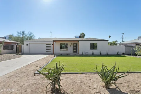 a front view of a house with a garden and patio