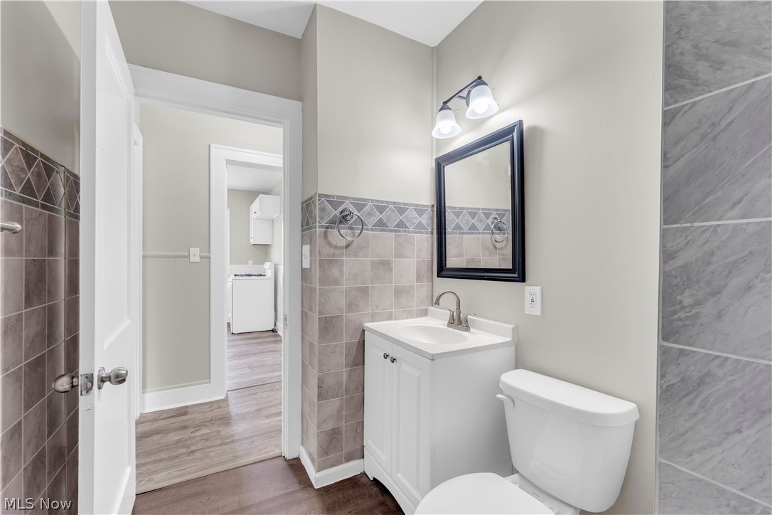 18123 McCracken Road Maple Heights, OH 44137 - Photo 23 of 27 Updated bathroom featuring a white vanity with integrated sink, a rectangular framed mirror, and a two-light fixture