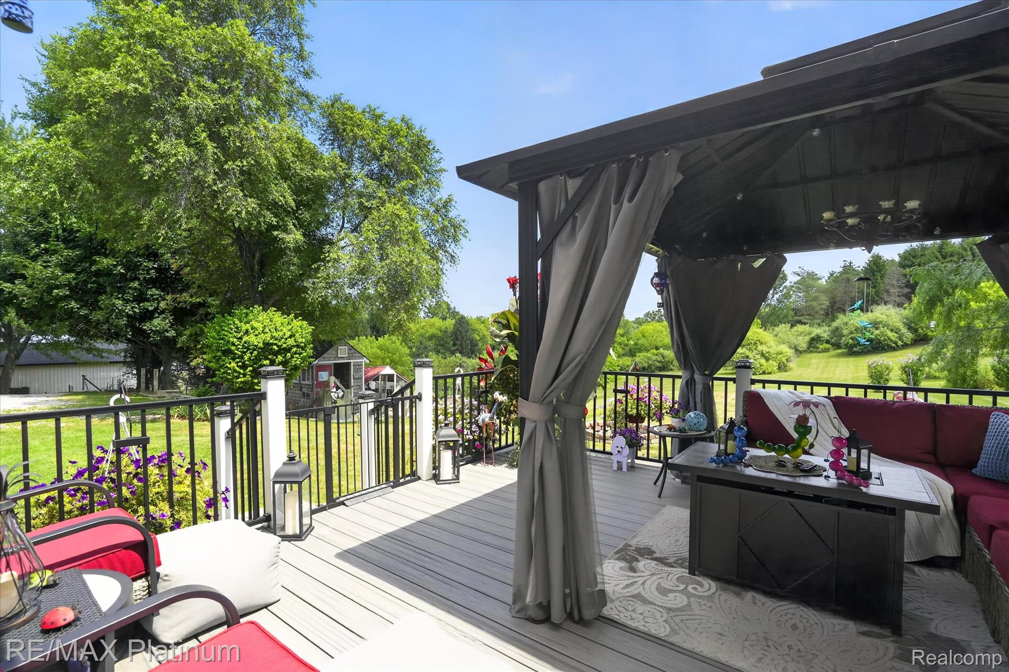 4457 Bradley Road Gregory, MI 48137 - Photo 38 of 79 Spacious deck with composite decking, featuring a black metal railing with white posts, and a dedicated covered gazebo area