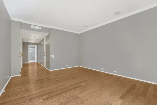 a view of an empty room with wooden floor