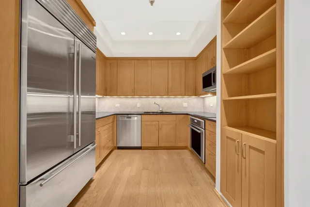 a kitchen with a refrigerator sink and cabinets