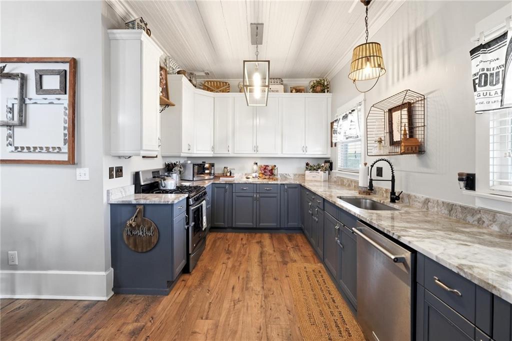 275 Strippling Street Ball Ground, GA 30107 - Photo 11 of 40 a kitchen with kitchen island granite countertop a sink stove and cabinets