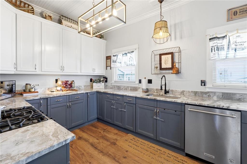 275 Strippling Street Ball Ground, GA 30107 - Photo 12 of 40 a kitchen with granite countertop stainless steel appliances stove a sink and dishwasher a oven with wooden floor