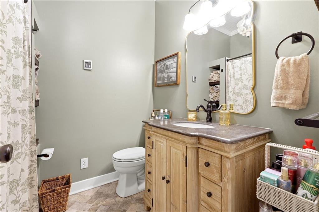 275 Strippling Street Ball Ground, GA 30107 - Photo 16 of 40 a bathroom with a sink a toilet and a mirror