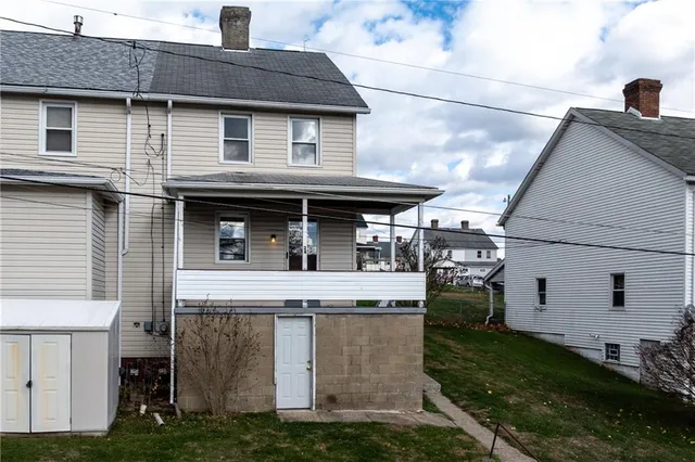 a view of a white house with large windows and a yard