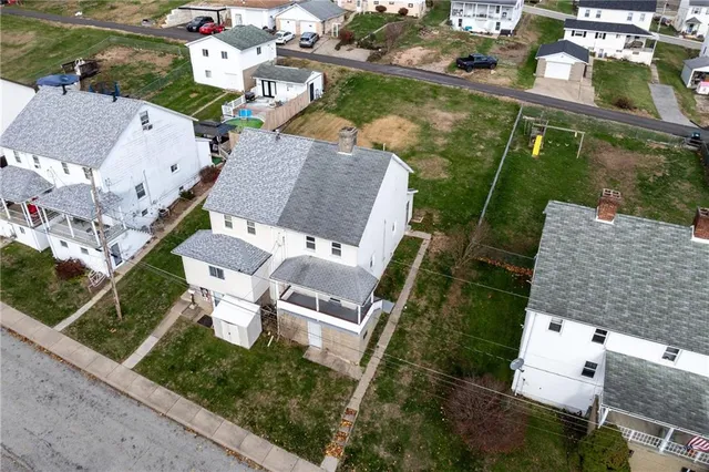 an aerial view of house with outdoor space and swimming pool