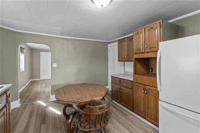 a kitchen with stainless steel appliances granite countertop a refrigerator a stove and a cabinets with wooden floor