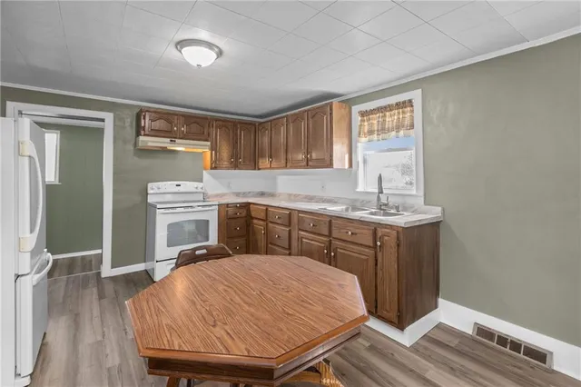 a kitchen with a sink cabinets and wooden floor