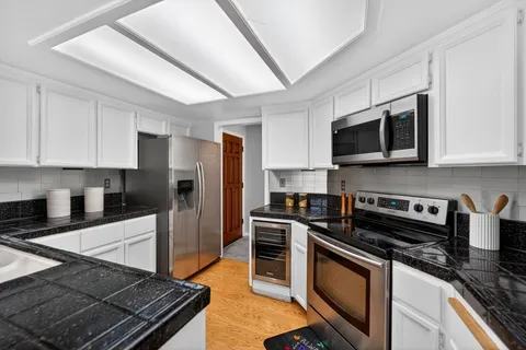 a kitchen with stainless steel appliances granite countertop a stove microwave sink and refrigerator