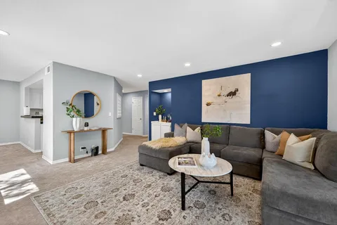 a living room with furniture a rug and kitchen view