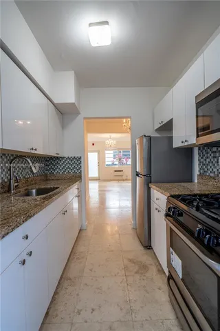 a kitchen with stainless steel appliances granite countertop a stove a sink and a refrigerator