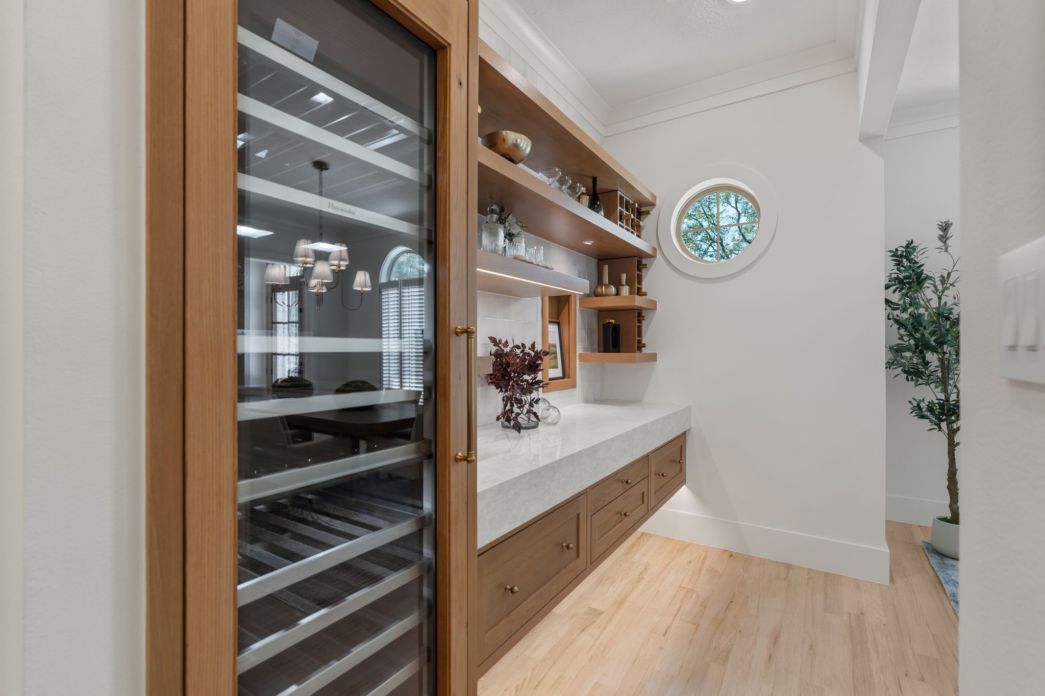 31 Hollymead Drive Spring, TX 77381 - Photo 10 of 50 A great addition to the dining area is this built-in 24" 92 bottle Thermador wine cooler, a sleek countertop with wooden drawers, and open shelving for glassware. A round window adds charm and natural light.